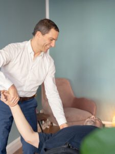 Osteopath behandelt die Schulter eines Patienten bei Impingement-Beschwerden