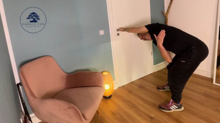Latissimus-Dehnung im Stand an der Tür mit seitlicher Rumpfneigung zur Verbesserung der Schulterbeweglichkeit