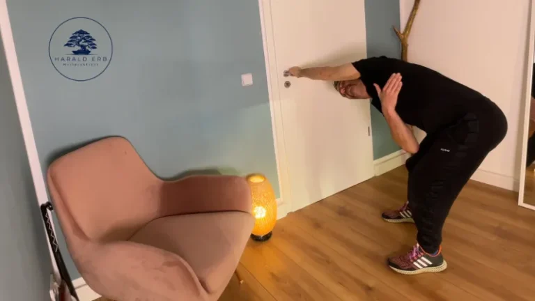 Latissimus-Dehnung im Stand an der Tür mit seitlicher Rumpfneigung zur Verbesserung der Schulterbeweglichkeit