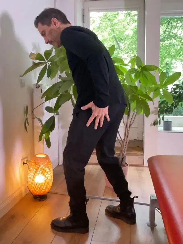 Osteopath Harald Erb zeigt die Schmerzregion bei Ischias – unterer Rücken und Gesäß