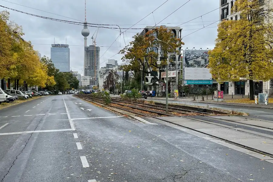 Prenzlauer Allee mit Straßenbahnhaltestelle M2 und Blick auf den Berliner Fernsehturm – gut erreichbar zur Osteopathie-Praxis Harald Erb im Kollwitzkiez