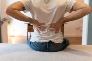 Mann hält sich den unteren Rücken – typisches Beschwerdebild in der Osteopathie-Praxis Harald Erb Berlin