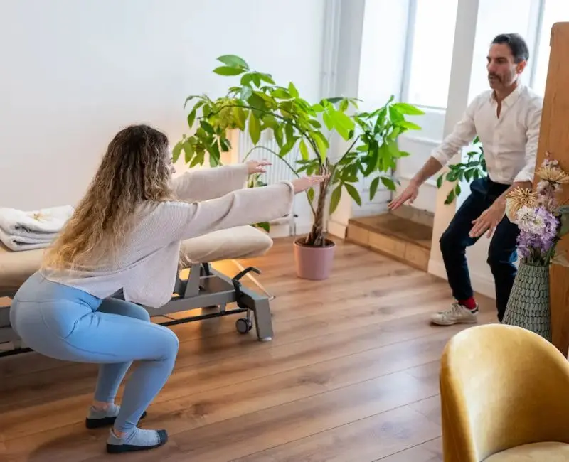Osteopath Harald Erb beobachtet Beweglichkeitstest einer Patientin in der Praxis Berlin Prenzlauer Berg